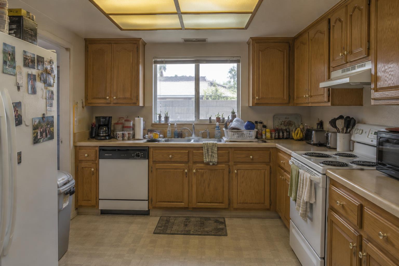 Outdated kitchen before renovation with oak cabinets and laminate counters